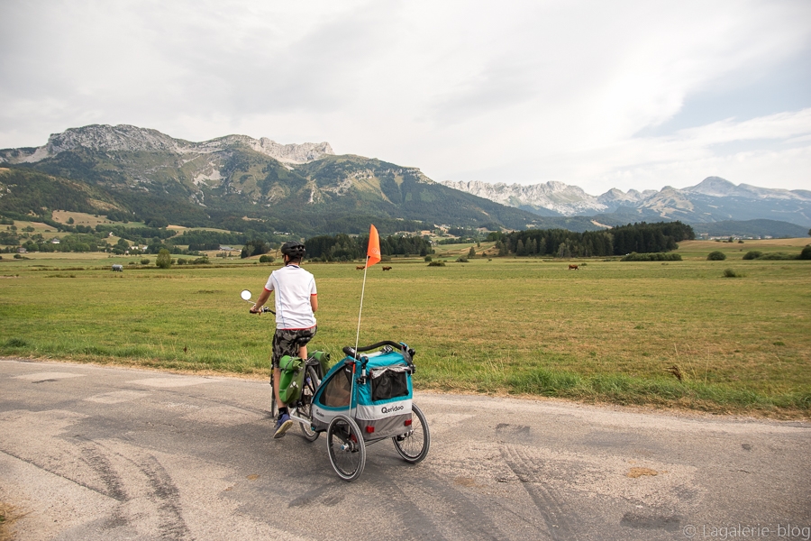 cycliste avec remorque devant les paysages du vercors